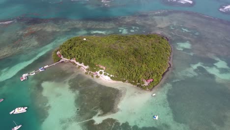 Aerial-drone-shot-during-sunny-afternoon.-Zoom-out-of-a-beautiful-island